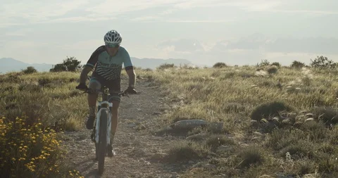 Mountain biker driving over a mountain trail Stock Footage 129884758