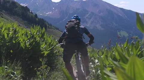 Mountain biker flys downhill Stock Footage 50963760