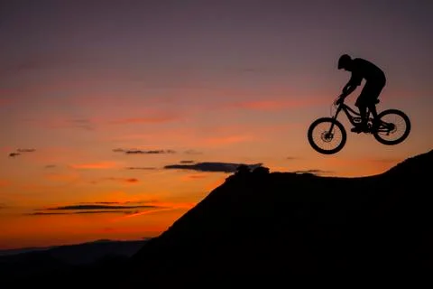 Mountain Biker jumping at sunset Stock Photos