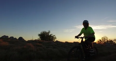 Mountain biker passing by at sunset Stock Footage 82355900