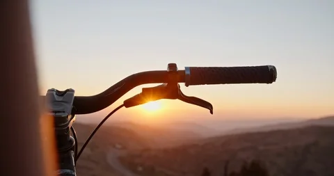 Mountain biker putting his hands on bicycle wheel, ready to go down the mountain Stock-Footage 97380939