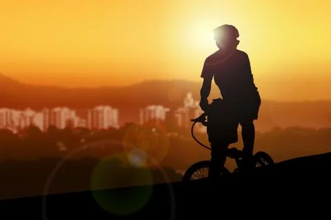 Mountain biker resting while watching sunset Stock Photos