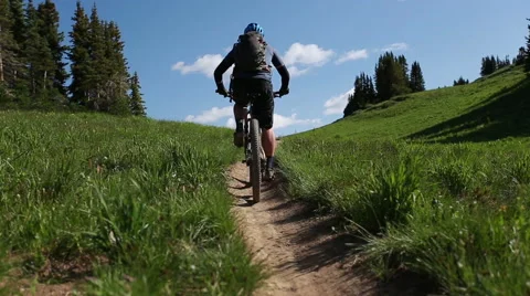 Mountain biker rides up dirt path 스톡 동영상 50965406