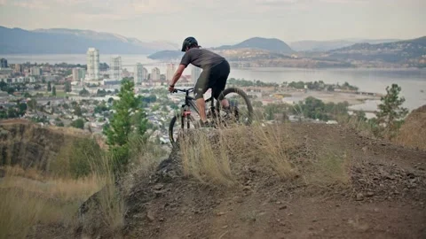 Mountain biker rides down beautiful bike trail with scenic views 库存影片 212164455