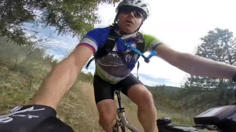Mountain biker rides singletrack trails in Colorado: handlebar view Stock Footage 49644430