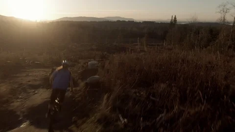 A mountain biker rides through a field of jumps in Bellingham WA Video stock 123077352
