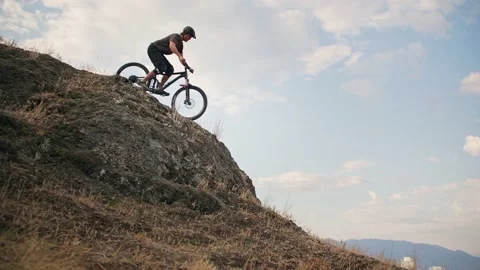Mountain biker riding down steep mountain cliff 库存影片 212161940