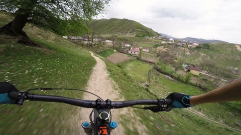 Mountain Biker Riding Fast Down A Path Towards A Mountain Village  Video stock 101581501