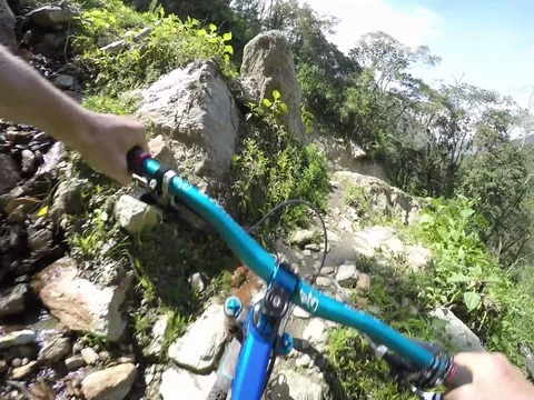 Mountain Biker Riding Fast On Edge Of Cliff Over A River 스톡 동영상 78251222