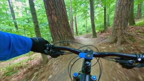 Mountain biker riding on flow single track trail in green forest. Stock Footage 138680444