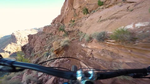 Mountain Biker Riding On A Narrow Path On The Edge Of A Massive Cliff Video stock 106912022