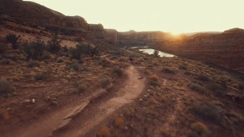 Mountain Biker Riding Into Sunset - Moab UT - Aerial Stock-Footage 85997311