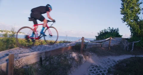 Mountain Biker riding through an offload trail by the water Stock Footage 104225001