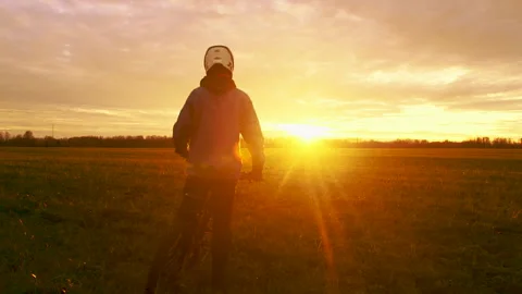 Mountain Biker Riding Through Open Field During Sunset Stock Footage 288575226