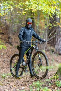 A Mountain Biker Skillfully Riding Through Vibrant Autumn Forest Trails and Stock Photos