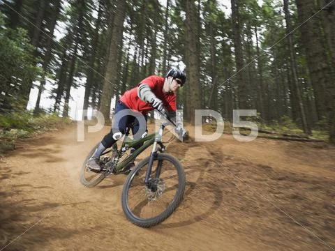 Mountain biker speeding down forest trail Stock Photos
