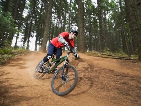 Mountain biker speeding down forest trail Stock Photos