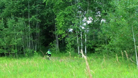 Mountain Biker Traverses Forest Trail On Narrow Path - Pan Left Video stock 164274264