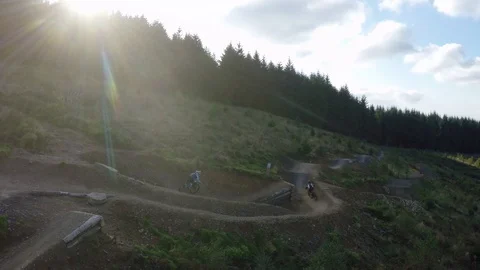 Mountain bikers cross over paths mid trail at high speed, drone aerial 4K Stock Footage 101107780