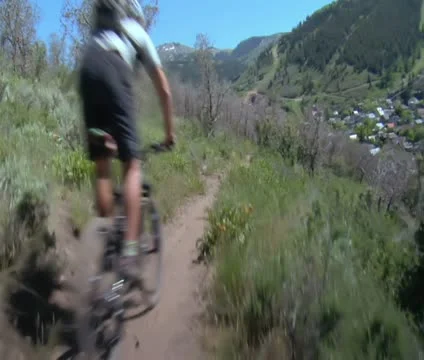 Mountain bikers fly down dusty Summer trail Stock Footage 21670253