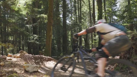 Mountain bikers going downhill in an evergreen forest 스톡 동영상 152885539