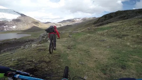 Mountain Bikers Riding Over Rough Terrain In An Alpine Valley With Glacier View 스톡 동영상 78250749