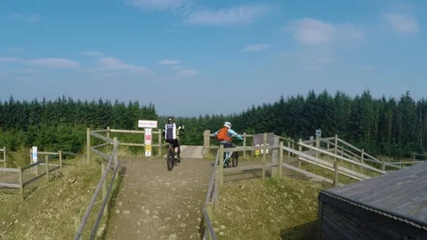 Mountain bikers thumbs up and continue onto trails reveal, drone aerial 4K Stock Footage 101107479