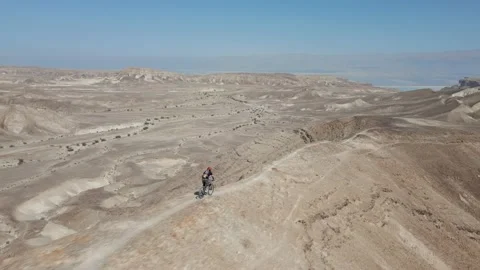 Mountain biking through a sharp edge mountain ridge in the desert, Aerial 스톡 동영상 239760287