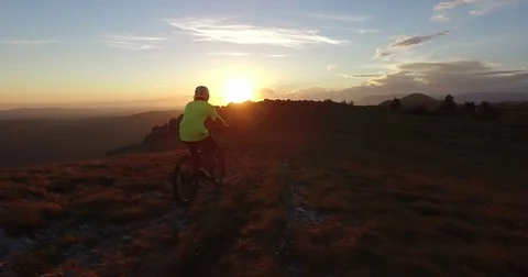 Mountain biking on the top of the mountain at sunset Stock Footage 82356016