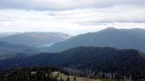 A mountain breathtaking river flows through the tranquil plain under the large Stock Photos