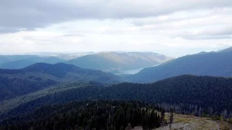 A mountain breathtaking river flows through the tranquil plain under the large Stock Photos