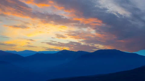 Mountain chain silhouette under dramatic cloudy sky at the twilight Stock Footage 250155419