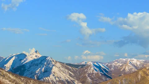 Mountain chain in snow under blue sky, bright winter travel  time lapse scene Stock Footage 169633683