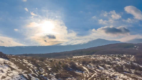 Mountain chain in snow under a sparkle sun time lapse scene Stock Footage 246804675