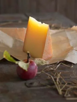 Mountain cheese and an apple with a bite taken out of it on a wooden surface Stock Photos