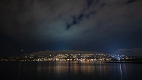 Mountain city reflected in water at night timelapse Stock Footage 298320732