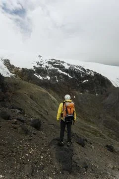 Mountain climber with backpack in front of a mountain Stock Photos