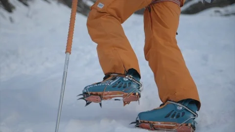 A mountain climber climbing up with crampons in the snow. Stock Footage