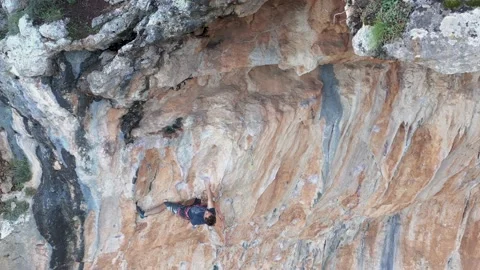 Mountain climber is climbing a vertical mountain wall Video stock 167728159