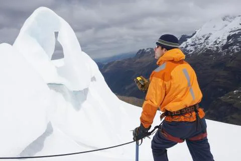Mountain Climber With Compass By Ice Formation In Mountains Stock Photos