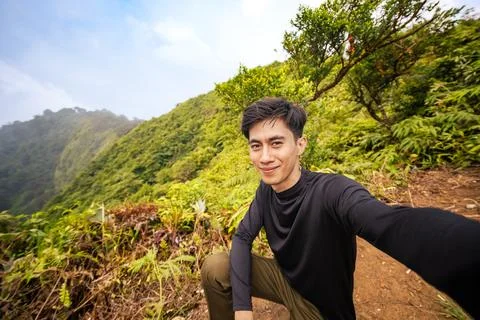 Mountain Climber Facing Camera with Breathtaking View Behind. Majestic Moun.. Stock Photos