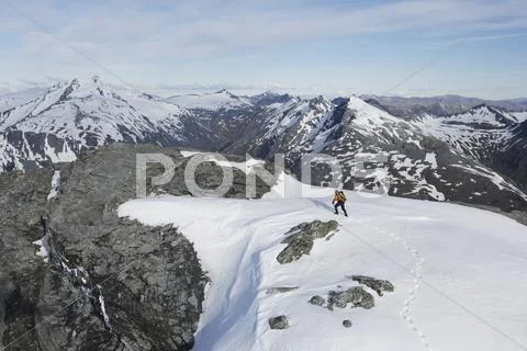 Mountain Climber Heading Across Snow For Distant Peak Stock Photos