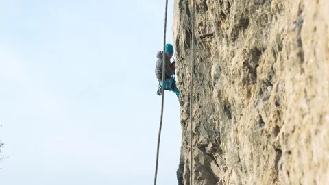 Mountain Climber Rappelling Down A Cliff with Group of Friends Stock Footage 121734453