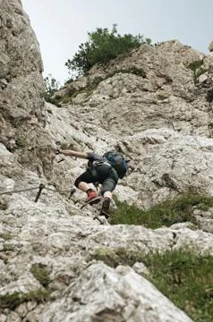 Mountain climber in steep vertical wall climbing the via ferrata in Julian Alps 스톡 사진