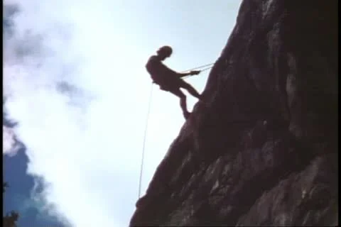 Mountain climbing school, repelling off top, backlighting, Grand Teton National Stock Footage