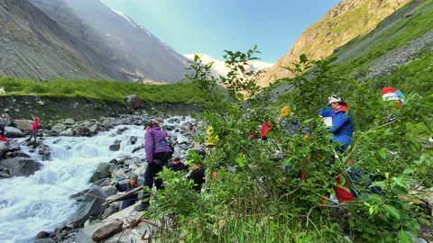 Mountain cold stormy river. Group of tourists at the crossing Vídeos de archivo 158666874