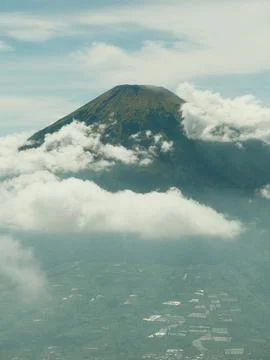 A mountain is covered in clouds and is in the background of a city Fotos Stock