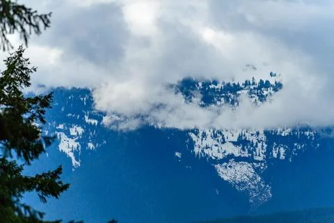 A mountain covered with coniferous forest in the clouds in Montana, USA Stock Photos