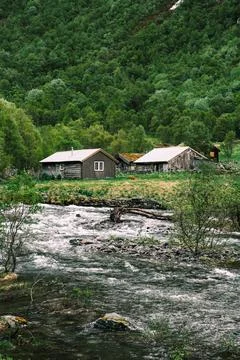 Mountain farm by the river rapids Stock Photos