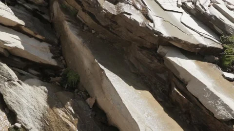 Mountain flat rocks with water dripping from melting snow above Stock Footage 52127023